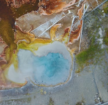 a large geothermal blue pool in yellowstone national park
