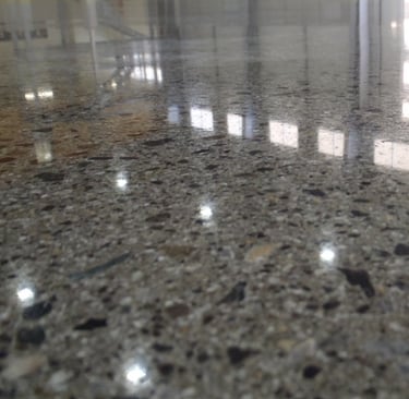 Sol en béton poli miroir, lisse et brillant, reflétant la lumière pour un effet moderne et élégant.