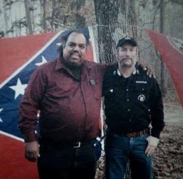 two men standing next to each other in front of a flag