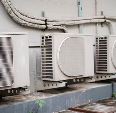 a group of air conditioners sitting on a ledge
