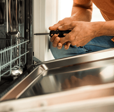 a man in a orange shirt is holding a screwdriver