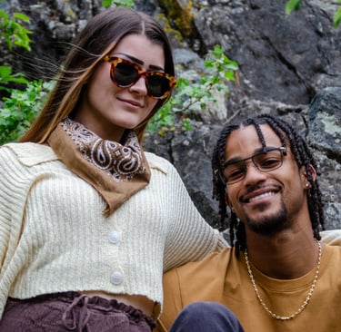 Young Man and woman standing outside, smiling, and wearing fashion eyewear