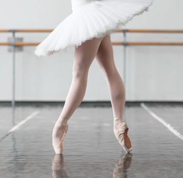 a ballerina in a white dress and a ballet shoe