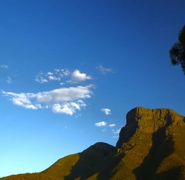 Golden-lit Bluff Knoll mountain under a clear blue sky