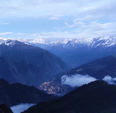Snow-capped mountains and valleys under an evening sky