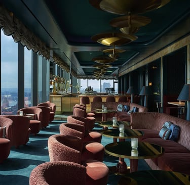 a room with a couch and chairs and a bar Nour Nagy Designs London interior Design