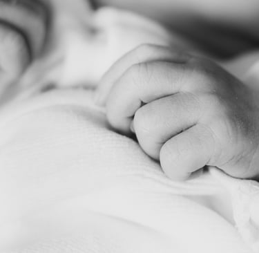 a baby's hand on a blanket