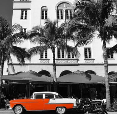 a classic red car parked in front of an art deco building