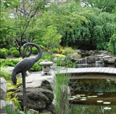 a statue of a crane standing on a wooden deck