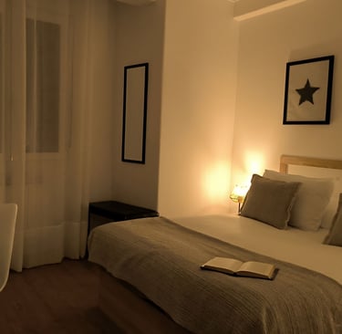 Habitación con cama de matrimonio en Hotel Arias, Vigo, con ventana y escritorio con ordenador.