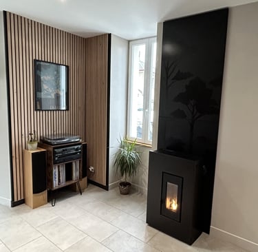 Poêle à granulés noir design avec flamme visible, intégré dans un salon moderne avec mur en tasseaux