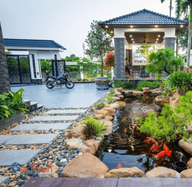 a garden with a pond and a house