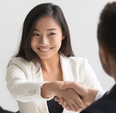 Une Chinoise avec le sourire qui serre la main lors d'un entretien d'embauche