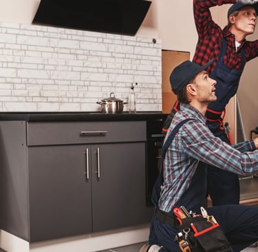 a man and woman working on a brick wall