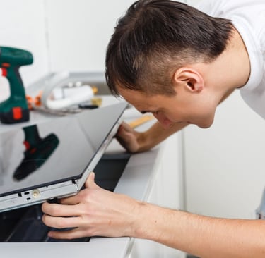 a man is looking at a stove to fix