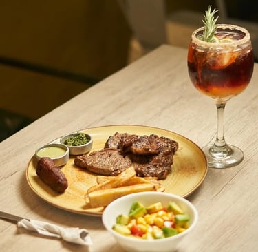 Delicosa carne con papas fritas ensalada y vino en Kabú Café Restaurante Calarcá Quindío