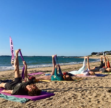 a group of people doing yoga on a beach