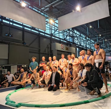 21 hommes et femmes prenant la pose sur un dohyo de Sumo