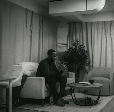 a man sitting on a couch looking at the back of a camera