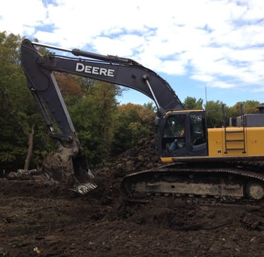 John Deere Excavator digging up dirt