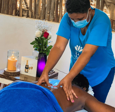 a woman in a blue shirt is getting a massage