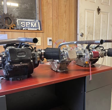 3 Go Kart race engines on display sitting on a desk.