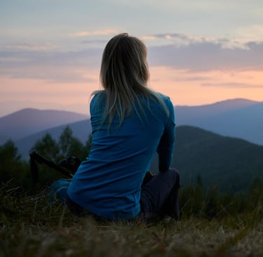 Solo female traveler overlooking the mountains during sunset