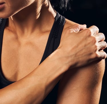 a woman holding her shoulder in discomfort