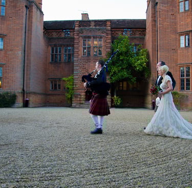 newly weds walking behind bagpiper 