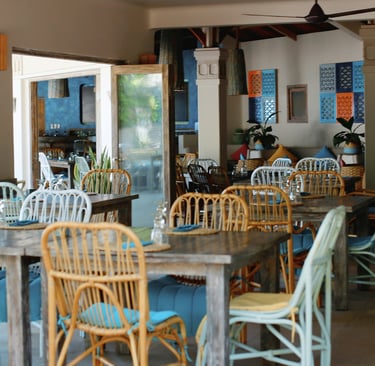 Empty cafe interior in Vietnam with bamboo-style chairs, cushions and simple tables