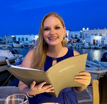 a smiling woman sitting at a table with a menu