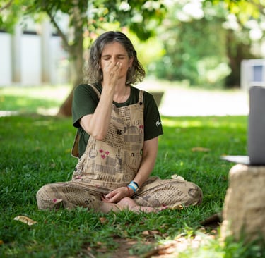 a woman sitting on the grass learning Online Yoga