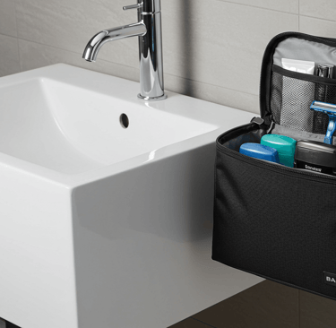 travel toiletry bag hanging on a hook by a bathroom sink