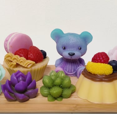 a wooden tray with a teddy bear, cupcakes and flowers made from soap