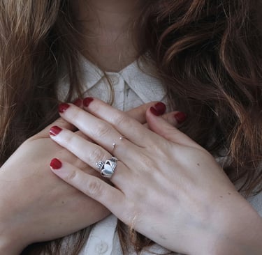 a woman with red nails with her hands on heart
