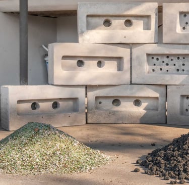 crushed glass and upcycled plastic aggregates in front of end product bricks