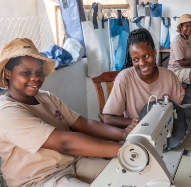 3 ladies smiling at work in the tailor shop