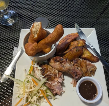 a plate of jerk chicken, plantains and festivals