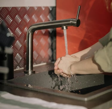 grifo de agua y manos de una persona que se lava