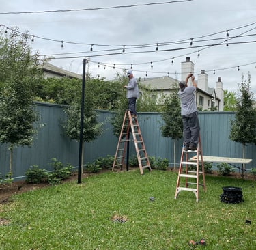 lighting technicians installing patio string lights