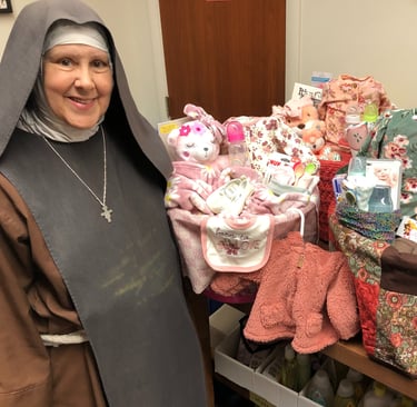 A fransican Daughter of Mary making baby baskets at the Rose Garden Mission