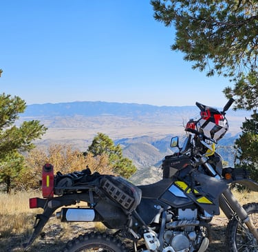 a motorcycle parked on a dirt road near a tree