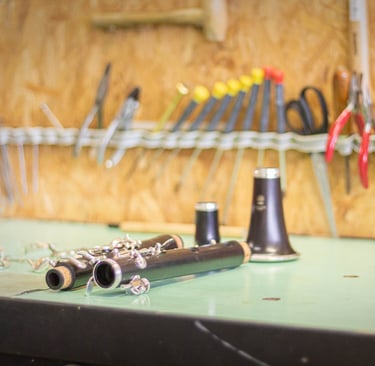Une clarinette partiellement démontée sur l'établi du réparateur d'instruments à vent