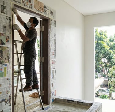 a man is painting a wall with newspaper paper