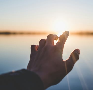 Hand reaching toward sunrise symbolizing hope and new beginnings after probate
