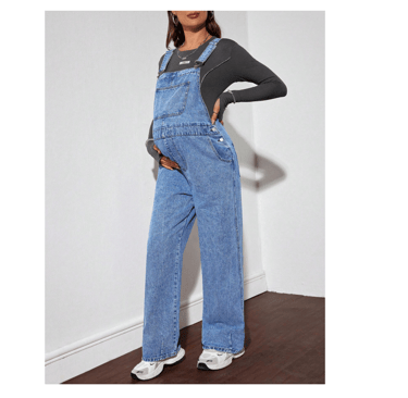 Pregnant person wearing loose fit maternity denim bib overalls for fall.