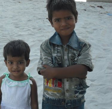 two young children standing in the sand