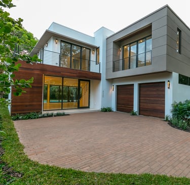 a brick driveway to a square looking custom designed luxury home