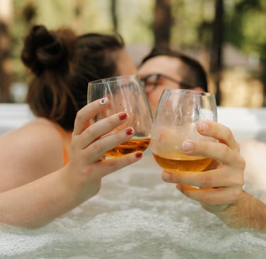 a couple of people in a hot tub drinking whiskey