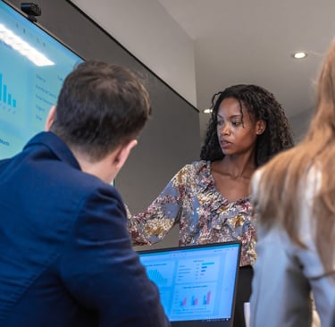 Woman presenting data on a screen to colleagues during a meeting.